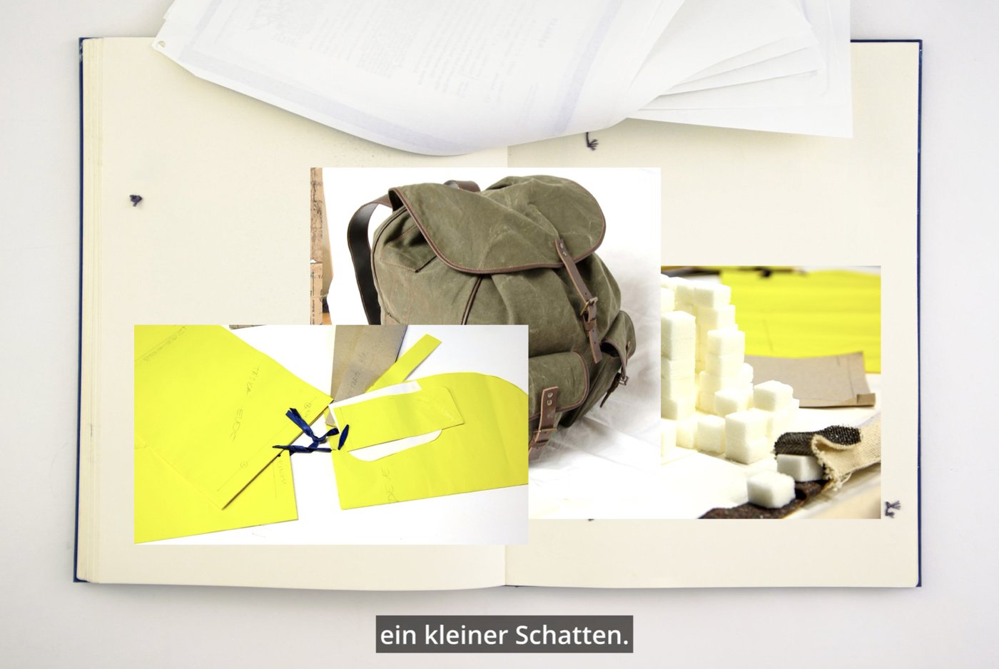 Das Bild zeigt zwei Seiten des Forschungstagebuchs, das den schriftlichen Teil der Dissertation begleitet. Die Künstlerin hat auf diesen Seiten einige Fotos als Collage über den Wiederherstellungsprozess des Rucksacks ihres Großvaters, den er während der Zwangsarbeit trug, platziert.