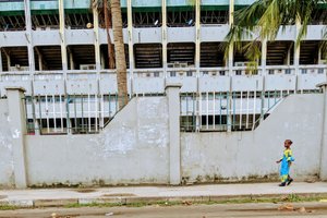 Ein junges Mädchen läuft eine Straße in Lagos entlang.