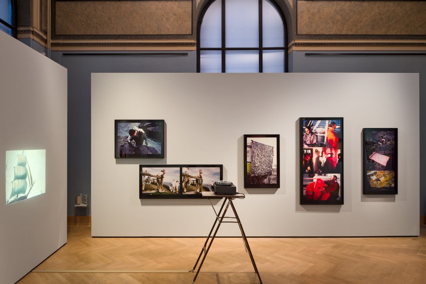 Ausstellungsansicht mit einer Wand voll Fotos