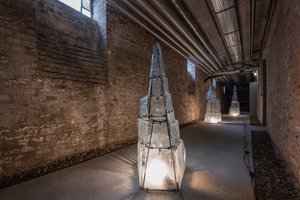 basement corridor with brick walls with three glass pyramids illuminated from the inside with light