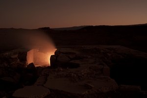 Picture of a stone landscape under dark sky, in the middle the floor breaks up and light shines through