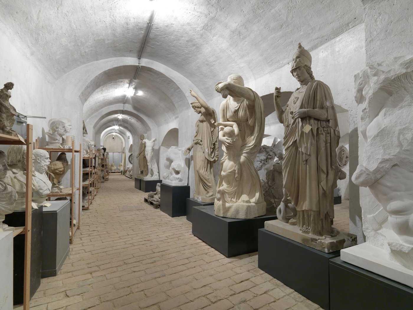 Photo of a room with vaults in which several Greek sculptures in different poses are standing close to each other