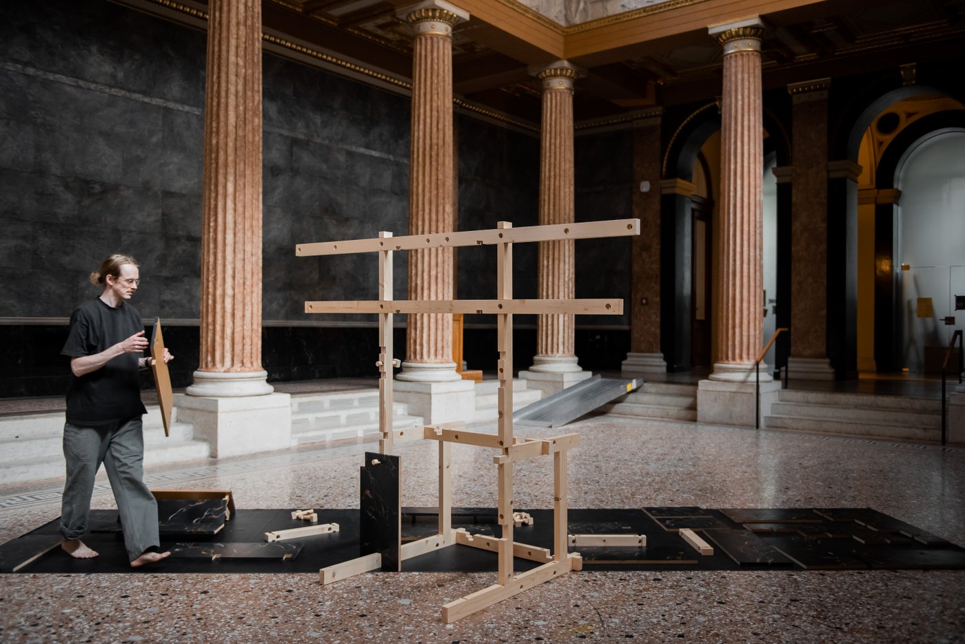 Person building a wooden construction in a hall